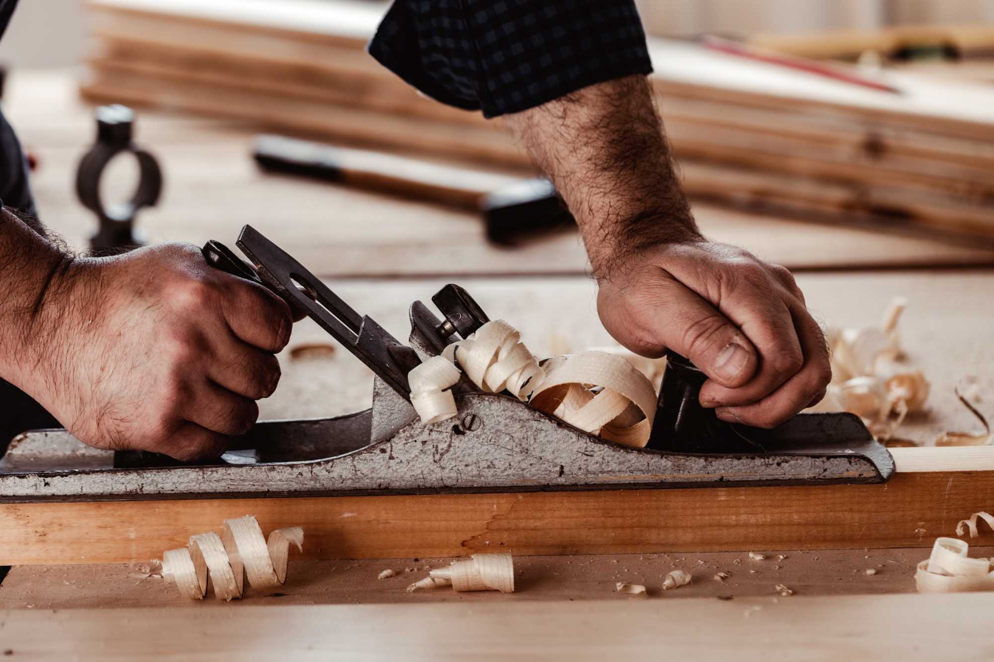 Carpenter sanding a timber chair in the workshop